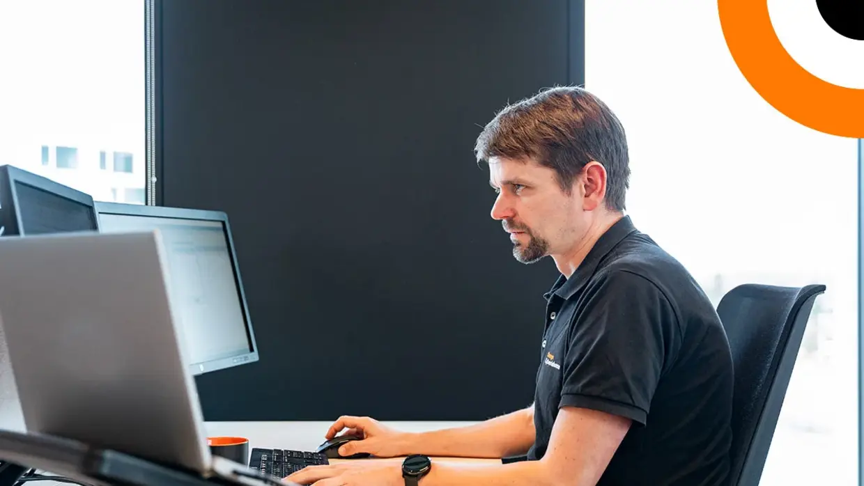 Un homme assis devant un ordinateur de bureau