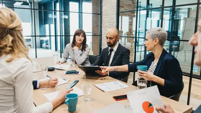 Business people around a table discussion figures