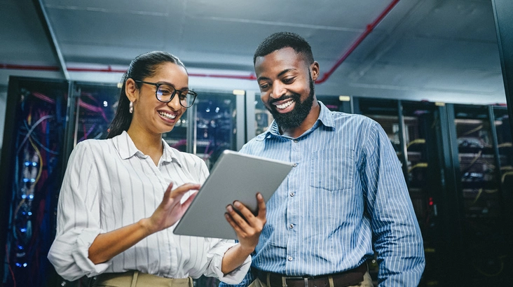 Un homme et une femme qui regardent une tablette dans un centre de donnée