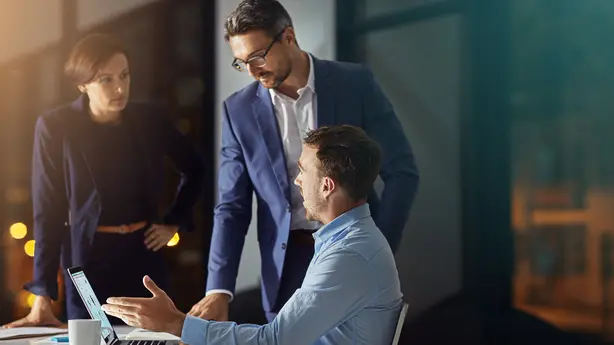 3 personnes se parlent autour d'un ordinateur