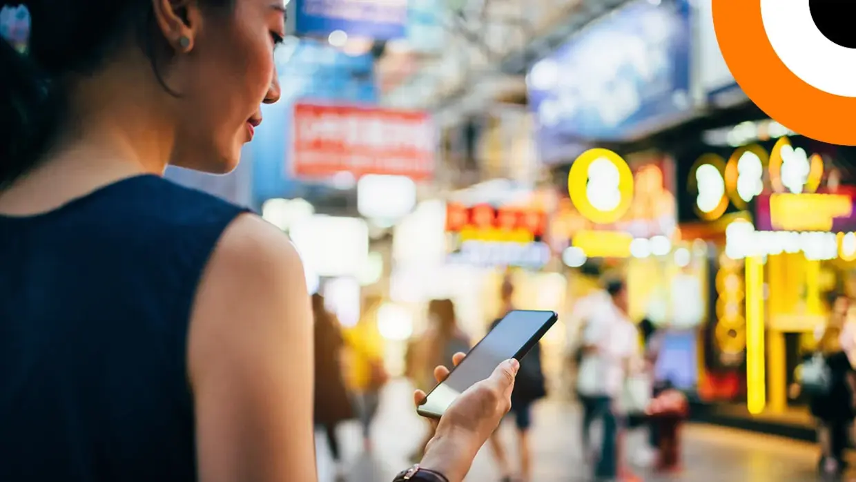 Qu'est-ce que Swift CSP ? Une jeune femme consulte son smartphone dans la rue.