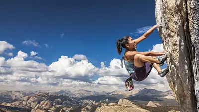 A woman free climbing the side of a cliff