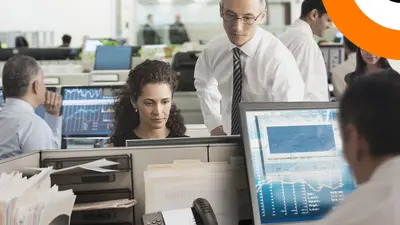 DORA et la sécurisation du secteur financier. Des personnes du secteur financier dans une salle avec des écrans d'ordinateurs