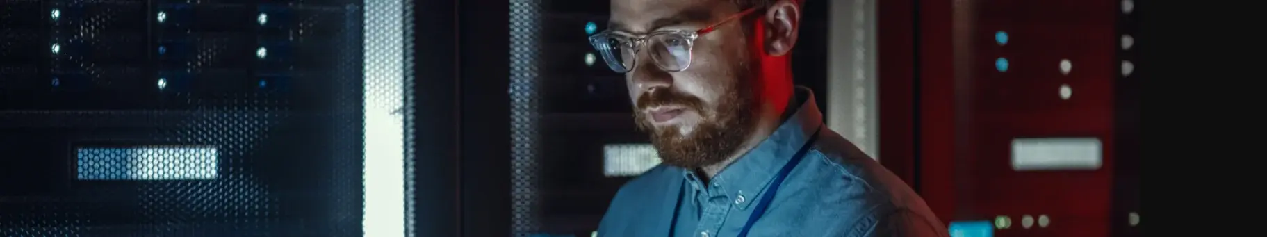 un homme regarde un écran ordinateur portable depuis un centre de sécurité