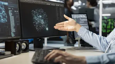 Close up of programmer looking at computer monitor in data center, running scripts