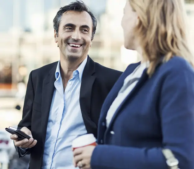 Two business professionals having an informal conversation outdoors