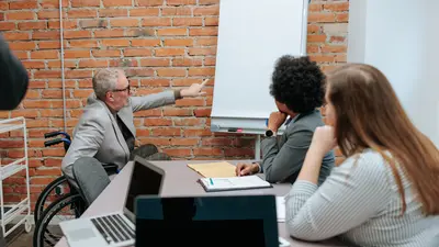 Man in wheelchair leading a white-boarding session