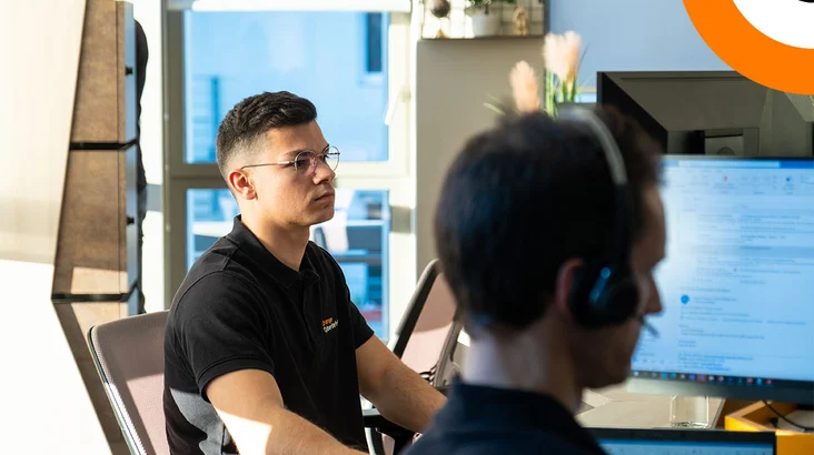 Orange Cyberdefense premier expert en cybersécurité certifié XSIAM Select. Deux experts en cybersécurité travaillent côte à côté devant leurs ordinateurs.