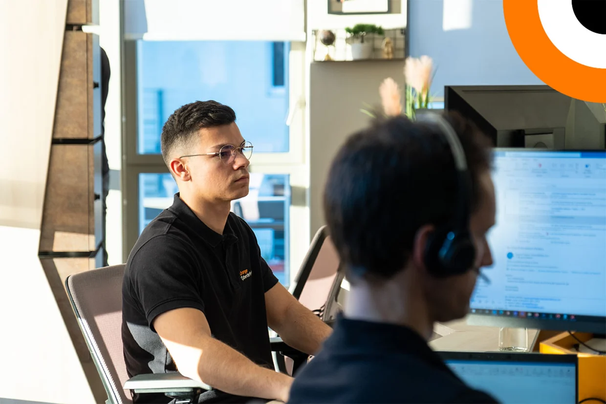 Orange Cyberdefense premier expert en cybersécurité certifié XSIAM Select. Deux experts en cybersécurité travaillent côte à côté devant leurs ordinateurs.