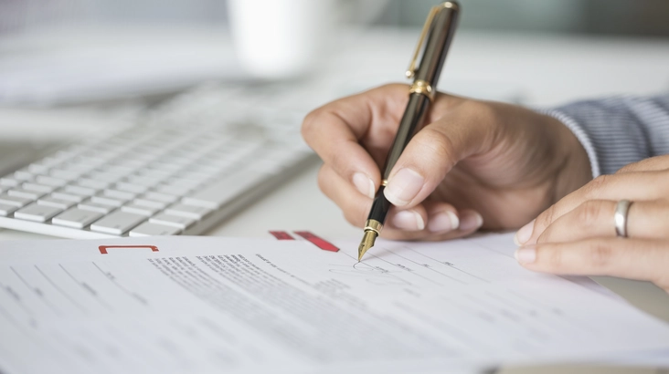 Une femme signe un document contractuel
