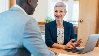 Two business people at a table with a laptop