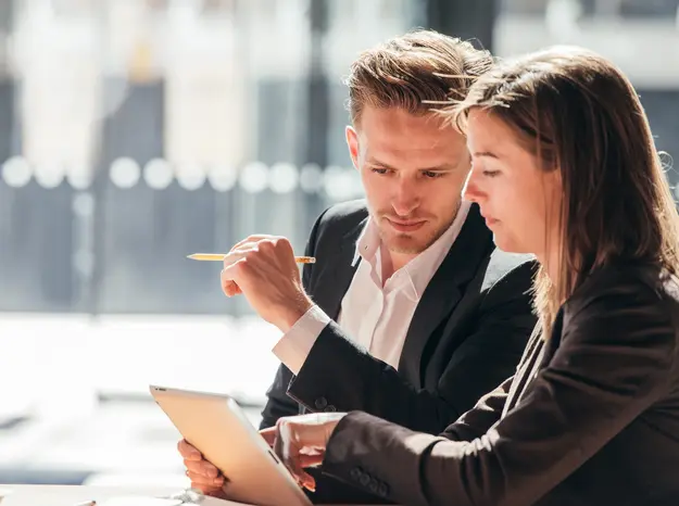 man and woman looking at a tablet