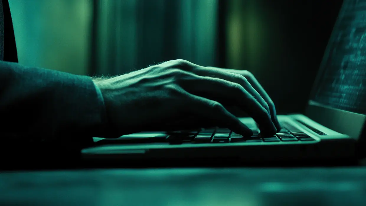 Person tippt auf Laptop Tastatur