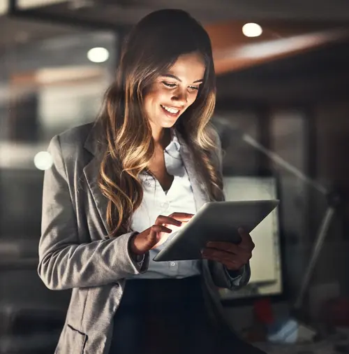 Une femme regarde sa tablette tactile qu'elle tient dans les mains