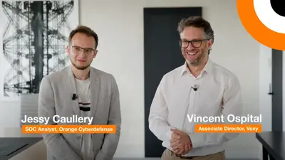 La complémentarité entre la solution Micro-SOC et la société d'infogérance Voxy. Deux professionnels en cybersécurité se tiennent côte à côte en souriant pour les besoins d'un témoignage vidéo.