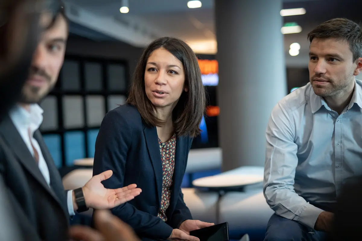 Three people in a business meeting discussing