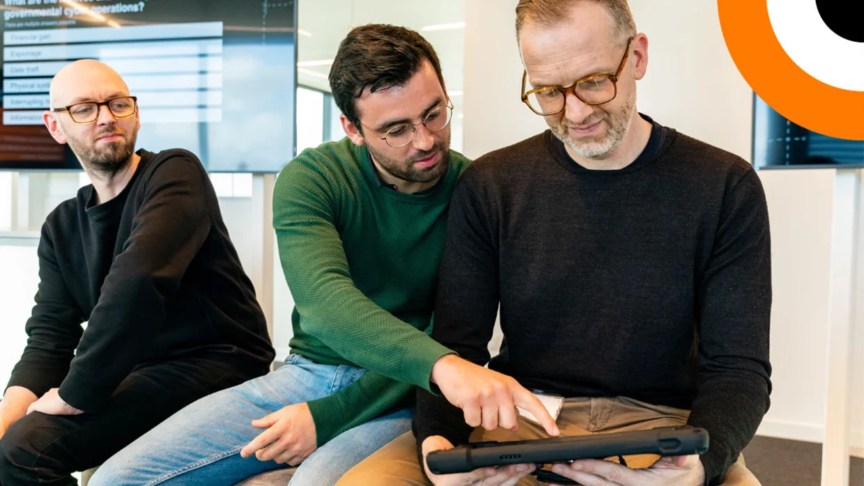 Les rapports du CERT. Plusieurs personnes travaillant ensemble échangent des informations de manière conviviale.