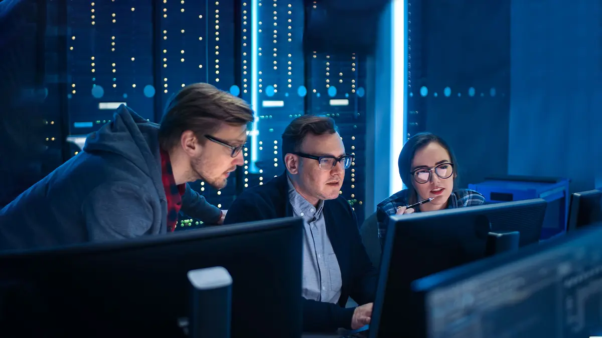 Trois hommes dans des locaux de cybersécurité ou un datacenter