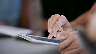 Nos recommandations pour lutter contre les phishing de faux vaccins anti COVID. Des mains sur une tablette.